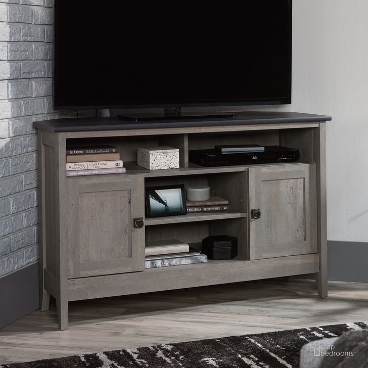 The appearance of August Hill Corner Tv Stand In Mystic Oak designed by Sauder in the country / farmhouse interior design. This mystic oak piece of furniture  was selected by 1StopBedrooms from August Hill Collection to add a touch of cosiness and style into your home. Sku: 433855. Product Type: TV Stand. Material: Engineered Wood. Image1