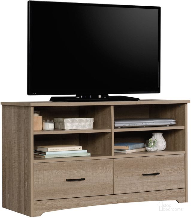 The appearance of Beginnings Tv Stand In Summer Oak designed by Sauder in the transitional interior design. This summer oak piece of furniture  was selected by 1StopBedrooms from Beginnings Collection to add a touch of cosiness and style into your home. Sku: 424258. Product Type: TV Stand. Material: Engineered Wood. Image1