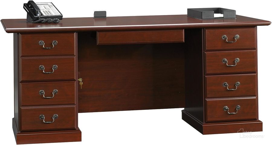 The appearance of Heritage Hill Executive Desk In Classic Cherry designed by Sauder in the traditional interior design. This classic cherry piece of furniture  was selected by 1StopBedrooms from Heritage Hill Collection to add a touch of cosiness and style into your home. Sku: 109843. Product Type: Executive Desk. Material: Engineered Wood. Image1