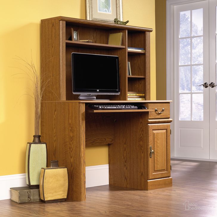 The appearance of Orchard Hills Computer Desk With Hutch In Carolina Oak designed by Sauder in the country / farmhouse interior design. This carolina oak piece of furniture  was selected by 1StopBedrooms from Orchard Hills Collection to add a touch of cosiness and style into your home. Sku: 401353. Product Type: Computer Desk. Material: Engineered Wood. Image1