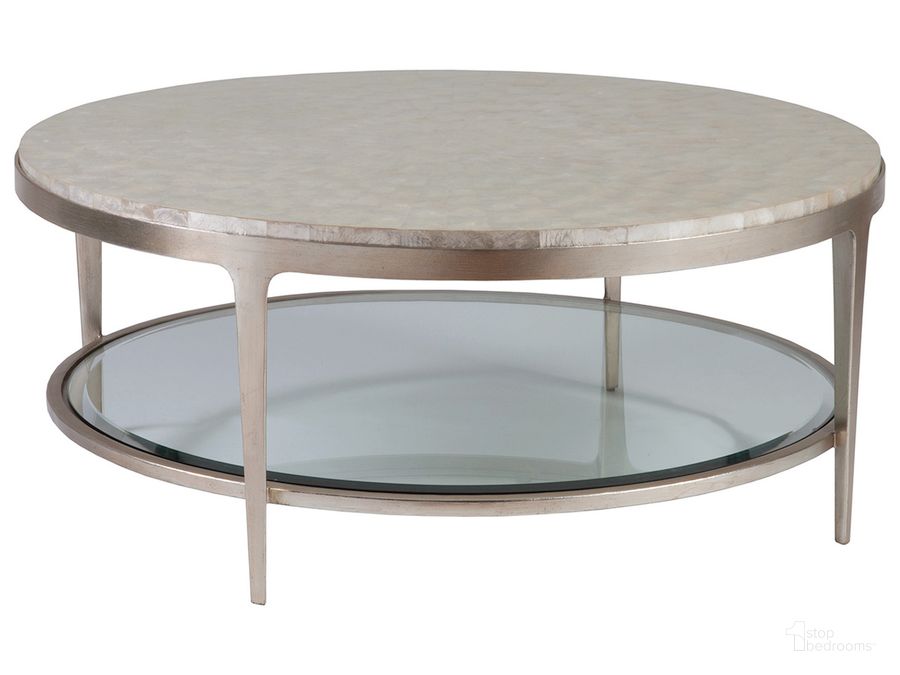 The appearance of Signature Designs Champagne Foil Gravitas Round Cocktail Table designed by Artistica Home in the transitional interior design. This gray piece of furniture  was selected by 1StopBedrooms from Signature Designs Collection to add a touch of cosiness and style into your home. Sku: 01-2050-943C. Product Type: Cocktail Table. Image1