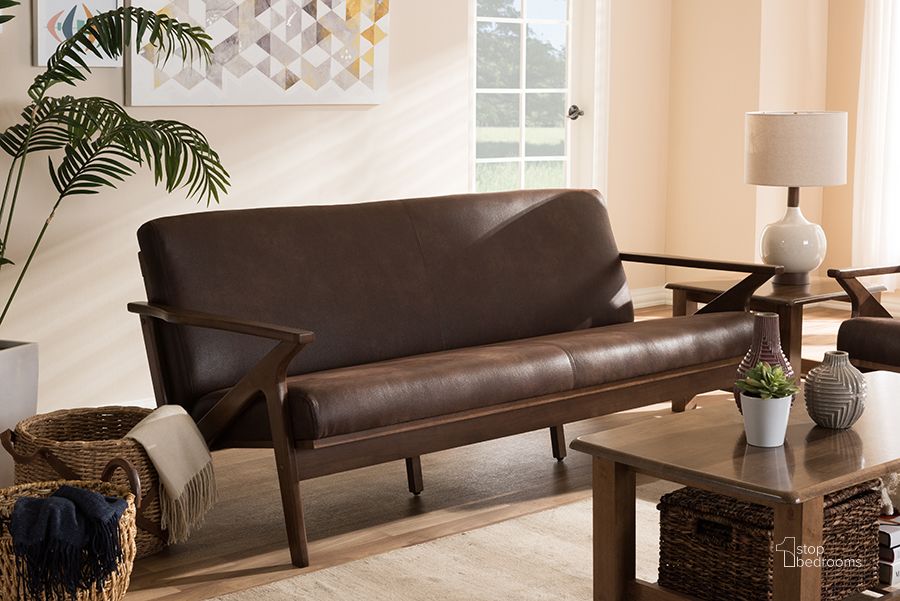 The appearance of Baxton Studio Bianca Mid-Century Modern Walnut Wood Dark Brown Distressed Faux Leather 3-Seater Sofa designed by Baxton Studio in the transitional interior design. This dark brown piece of furniture  was selected by 1StopBedrooms from Bianca Collection to add a touch of cosiness and style into your home. Sku: Bianca-Dark Brown/Walnut Brown-SF. Material: Leather. Product Type: Leather Sofa. Image1