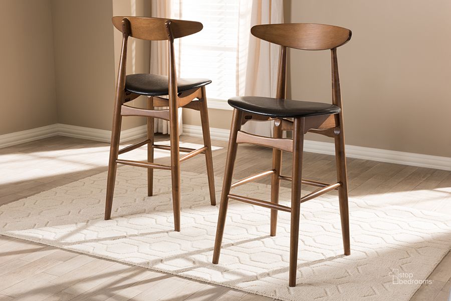 The appearance of Baxton Studio Flora Mid-Century Modern Black Faux Leather Upholstered Walnut Finished Bar Stool (Set Of 2) designed by Baxton Studio in the transitional interior design. This black piece of furniture  was selected by 1StopBedrooms from Flora Collection to add a touch of cosiness and style into your home. Sku: Flora-Black/Walnut-BS. Product Type: Barstool. Material: Rubberwood. Image1