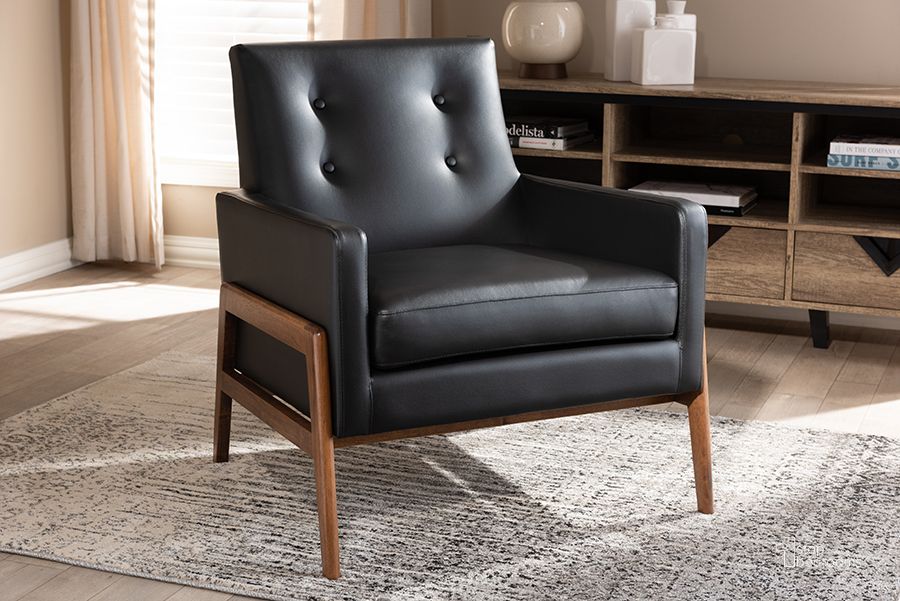 The appearance of Baxton Studio Perris Mid-Century Modern Black Faux Leather Upholstered Walnut Wood Lounge Chair designed by Baxton Studio in the transitional interior design. This black piece of furniture  was selected by 1StopBedrooms from Perris Collection to add a touch of cosiness and style into your home. Sku: BBT8042-Black-CC. Product Type: Lounge Chair. Material: Rubberwood. Image1