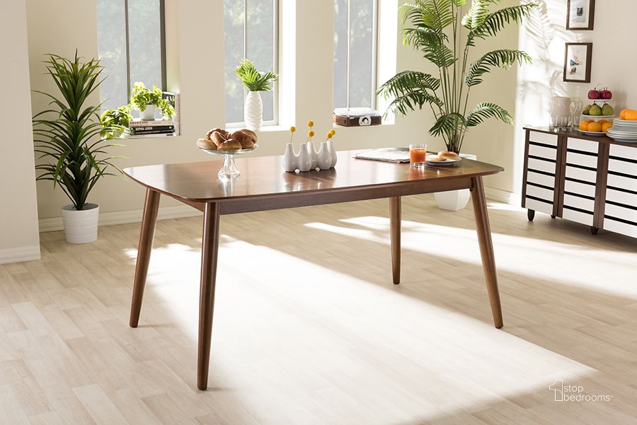 The appearance of Baxton Studio Flora Mid-Century Modern Oak Medium Brown Finishing Wood Dining Table designed by Baxton Studio in the transitional interior design. This oak piece of furniture  was selected by 1StopBedrooms from Flora Collection to add a touch of cosiness and style into your home. Sku: Flora-Medium Oak-DT. Table Base Style: Legs. Product Type: Dining Table. Table Top Shape: Rectangular. Material: Rubberwood. Image1