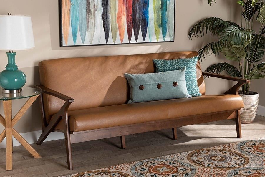 The appearance of Baxton Studio Bianca Mid-Century Modern Walnut Brown Finished Wood and Tan Faux Leather Effect Sofa designed by Baxton Studio in the transitional interior design. This tan and walnut brown piece of furniture  was selected by 1StopBedrooms from Bianca Collection to add a touch of cosiness and style into your home. Sku: Bianca-Tan/Walnut Brown-SF. Material: Polyester. Product Type: Sofa. Image1