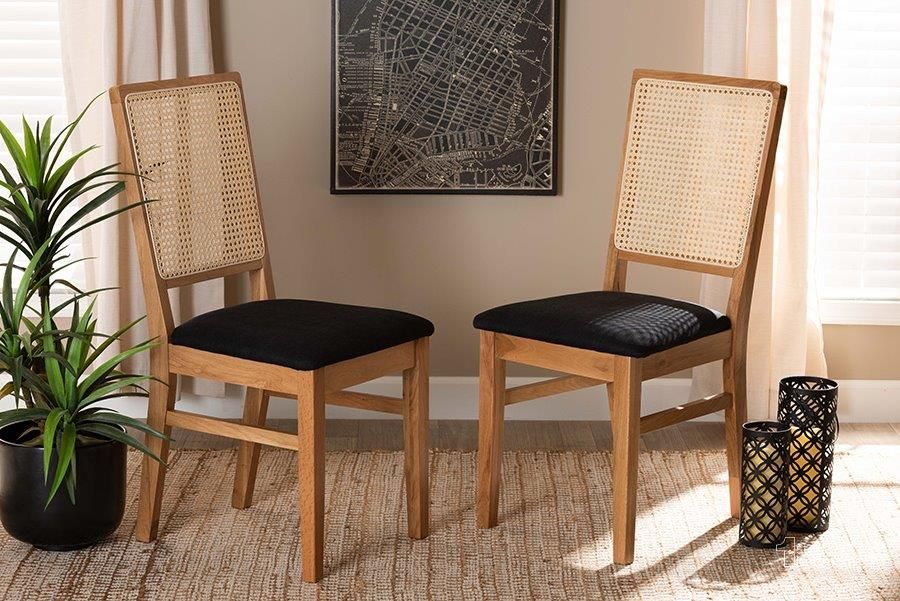 The appearance of Baxton Studio Idris Mid-Century Modern Black Fabric Upholstered and Oak brown Finished 2-Piece Rattan Dining Chair Set designed by Baxton Studio in the transitional interior design. This black and brown piece of furniture  was selected by 1StopBedrooms from Idris Collection to add a touch of cosiness and style into your home. Sku: SK9004-Oak-DC-2PK. Product Type: Dining Chair. Material: Rattan. Image1