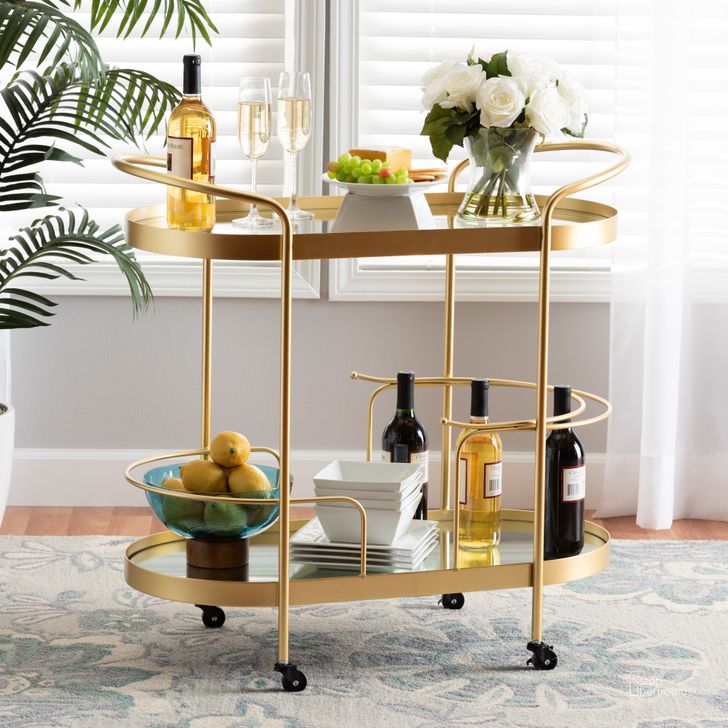 The appearance of Baxton Studio Kamal Modern and Contemporary Glam Brushed Gold Finished Metal and Mirrored Glass 2-Tier Mobile Wine Bar Cart designed by Baxton Studio in the glam interior design. This gold piece of furniture  was selected by 1StopBedrooms from Kamal Collection to add a touch of cosiness and style into your home. Sku: JY20A268-Gold-Cart. Material: Metal. Product Type: Bar Cart. Image1