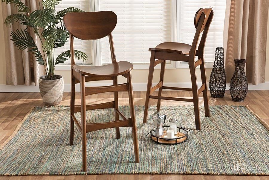 The appearance of Baxton Studio Katya Mid-Century Modern Walnut Brown Finished Wood 2-Piece Bar Stool Set designed by Baxton Studio in the transitional interior design. This walnut brown piece of furniture  was selected by 1StopBedrooms from Katya Collection to add a touch of cosiness and style into your home. Sku: RH378BP-Walnut Bent Seat-BS-2PK. Product Type: Barstool. Material: Rubberwood. Image1
