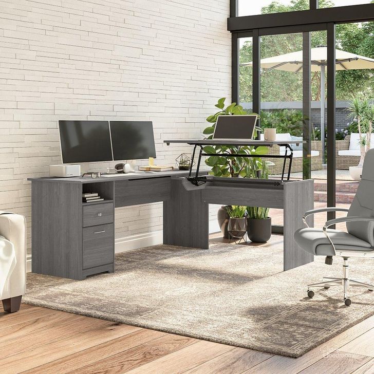 The appearance of Bush Furniture Cabot 72W 3 Position Sit To Stand L Shaped Desk in Modern Gray designed by Bush Furniture in the modern / contemporary interior design. This gray piece of furniture  was selected by 1StopBedrooms from Cabot Collection to add a touch of cosiness and style into your home. Sku: CAB050MG. Material: Wood. Product Type: Desk. Image1