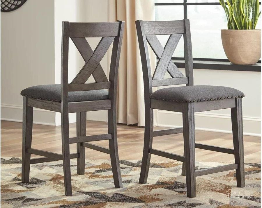 The appearance of Caitbrook Gray Upholstered Barstool Set of 2 designed by Signature Design by Ashley in the transitional interior design. This gray piece of furniture  was selected by 1StopBedrooms from Caitbrook Collection to add a touch of cosiness and style into your home. Sku: D388-124. Material: Fabric. Product Type: Barstool. Image1