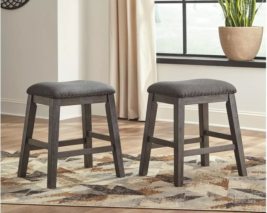 The appearance of Caitbrook Gray Upholstered Stool Set of 2 designed by Signature Design by Ashley in the transitional interior design. This gray piece of furniture  was selected by 1StopBedrooms from Caitbrook Collection to add a touch of cosiness and style into your home. Sku: D388-024. Material: Fabric. Product Type: Barstool. Image1