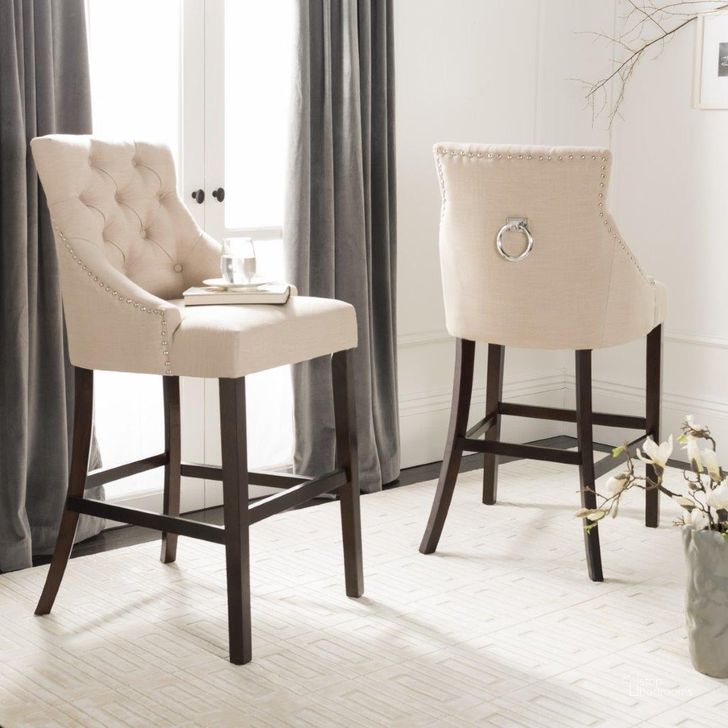 The appearance of Eleni Beige Tufted Wing Back Bar Stool designed by Safavieh in the modern / contemporary interior design. This beige piece of furniture  was selected by 1StopBedrooms from Eleni Collection to add a touch of cosiness and style into your home. Sku: BST6304E-SET2. Material: Wood. Product Type: Barstool. Image1