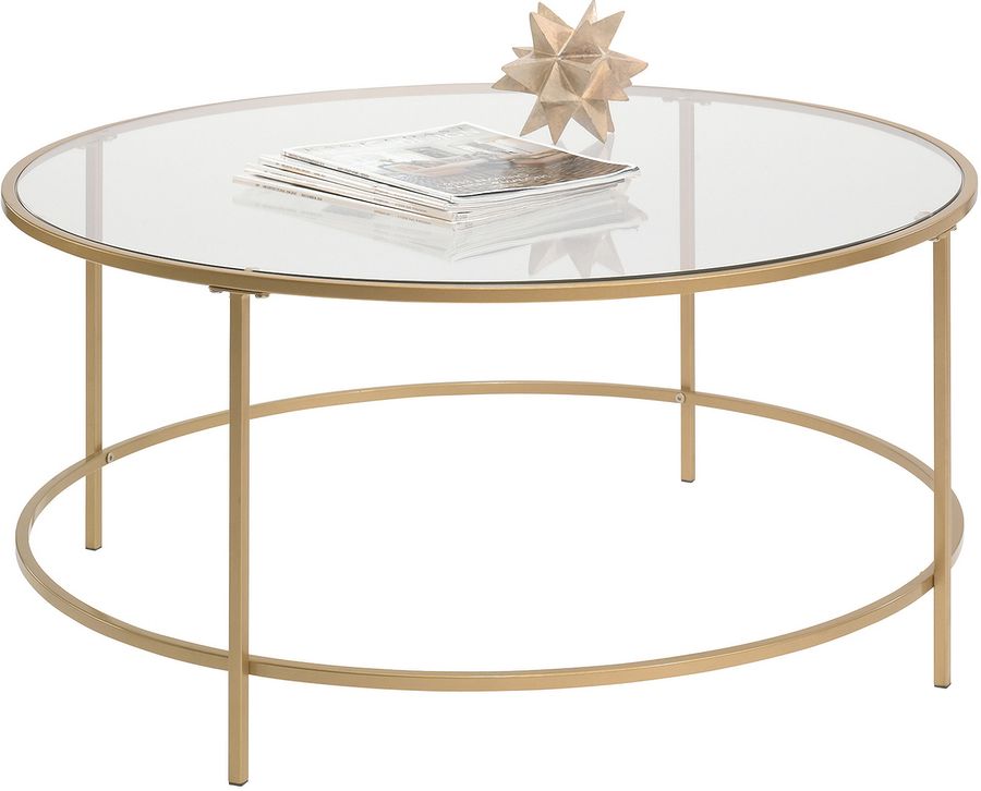 The appearance of International Lux Round Coffee Table In Satin Gold designed by Sauder in the transitional interior design. This satin gold piece of furniture  was selected by 1StopBedrooms from International Lux Collection to add a touch of cosiness and style into your home. Sku: 417830. Material: Metal. Product Type: Coffee Table. Image1