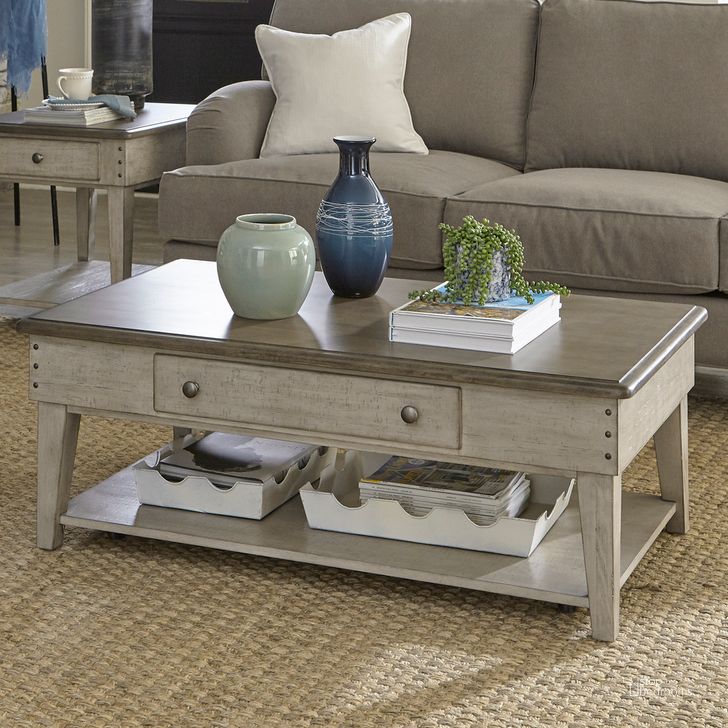 The appearance of Ivy Hollow Drawer Cocktail Table In Weathered Linen With Dusty Taupe Top designed by Liberty in the country / farmhouse interior design. This taupe piece of furniture  was selected by 1StopBedrooms from Ivy Hollow Collection to add a touch of cosiness and style into your home. Sku: 457-OT1010. Product Type: Cocktail Table. Material: Poplar. Image1