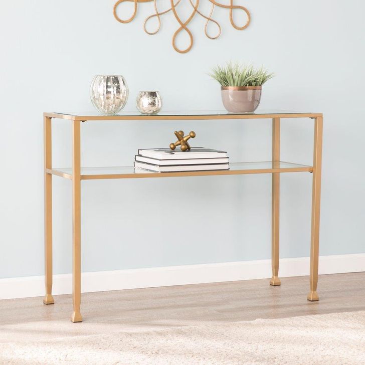 The appearance of Jaymes Gold Metal And Glass Console Table designed by SEI Furniture in the transitional interior design. This gold piece of furniture  was selected by 1StopBedrooms from Jaymes Collection to add a touch of cosiness and style into your home. Sku: CK5773. Product Type: Console Table. Material: Iron. Image1