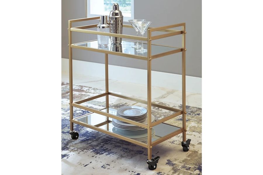 The appearance of Kailman Gold Bar Cart designed by Signature Design by Ashley in the modern / contemporary interior design. This gold piece of furniture  was selected by 1StopBedrooms from Kailman Collection to add a touch of cosiness and style into your home. Sku: A4000095. Material: Glass. Product Type: Bar Cart. Image1