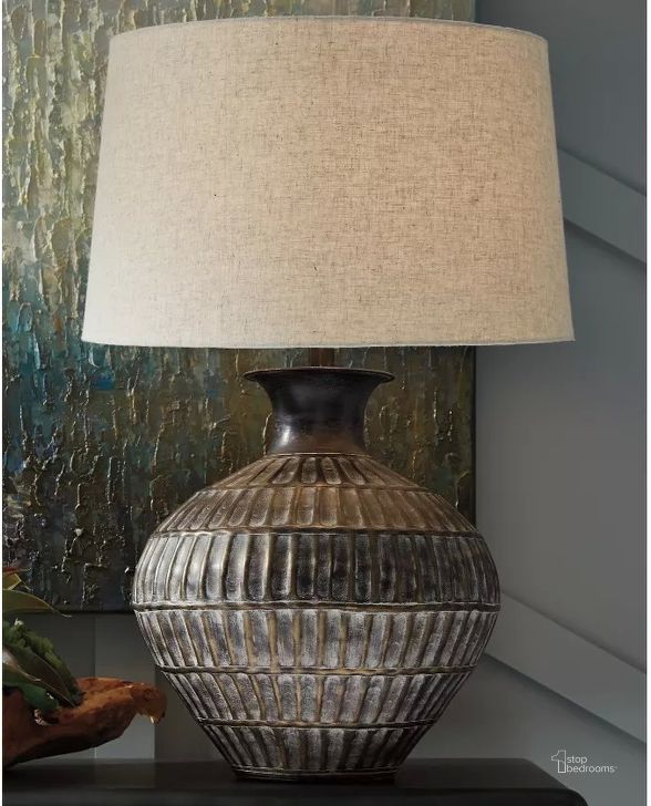 The appearance of Magan Antique Bronze Metal Table Lamp designed by Signature Design by Ashley in the transitional interior design. This antique bronze piece of furniture  was selected by 1StopBedrooms from Magan Collection to add a touch of cosiness and style into your home. Sku: L207354. Product Type: Table Lamp. Image1