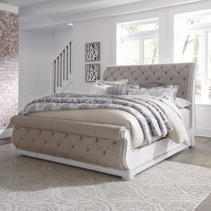 The appearance of Magnolia Manor Antique White King Upholstered Sleigh Bed designed by Liberty in the rustic / southwestern interior design. This antique white piece of furniture  was selected by 1StopBedrooms from Magnolia Manor Collection to add a touch of cosiness and style into your home. Sku: 244-BR22FU;244-BR22HU;244-BR92. Bed Type: Sleigh Bed. Material: Fabric. Product Type: Sleigh Bed. Bed Size: King. Image1
