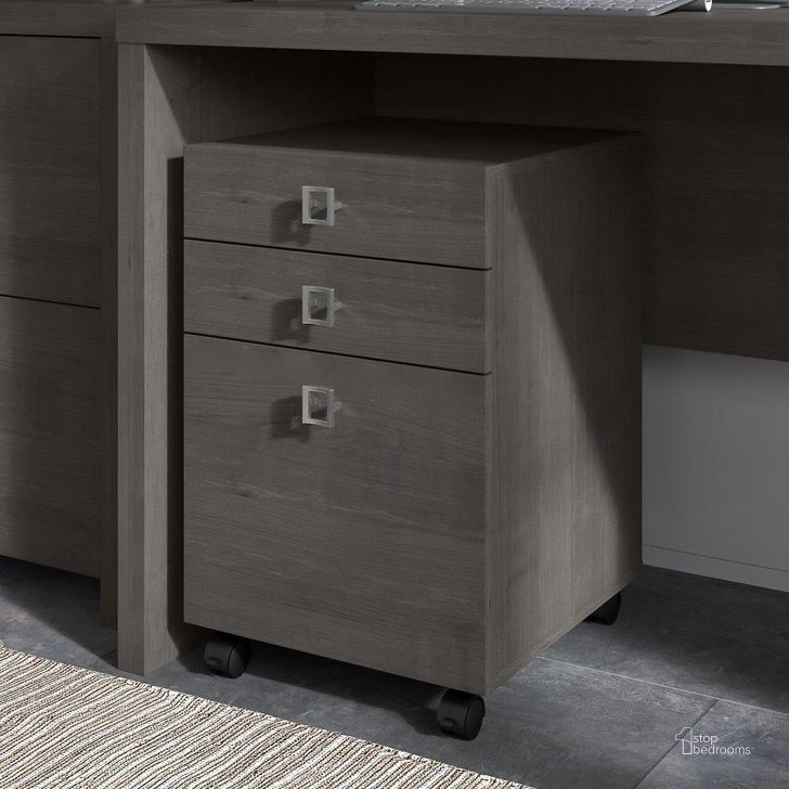 The appearance of Office by Kathy Ireland Echo 3 Drawer Mobile File Cabinet in Charcoal Maple designed by Bush Furniture in the modern / contemporary interior design. This charcoal piece of furniture  was selected by 1StopBedrooms from Echo Collection to add a touch of cosiness and style into your home. Sku: KI60301-03. Product Type: Mobile Filing Cabinet. Image1