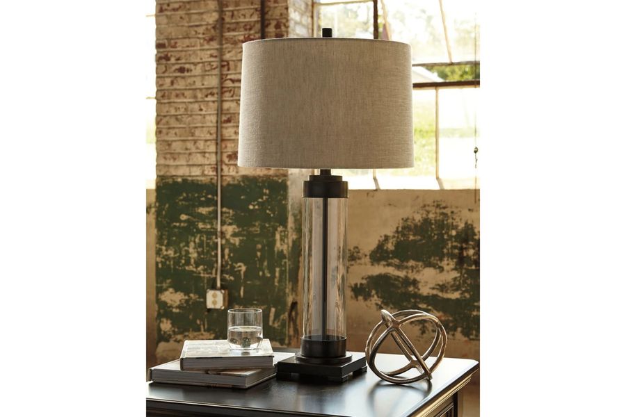 The appearance of Ramoana Clear/Bronze Desk and Buffet Lamp designed by Windsor Home in the traditional interior design. This clear/bronze piece of furniture  was selected by 1StopBedrooms from Ramoana Collection to add a touch of cosiness and style into your home. Sku: L430164. Material: Glass. Product Type: Table Lamp. Image1
