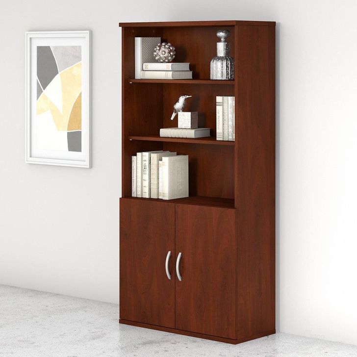 The appearance of Bush Business Furniture Studio C 5 Shelf Bookcase with Doors in Hansen Cherry designed by Bush Furniture in the transitional interior design. This cherry piece of furniture  was selected by 1StopBedrooms from Studio C Collection to add a touch of cosiness and style into your home. Sku: STC015HC. Product Type: Bookcase. Image1
