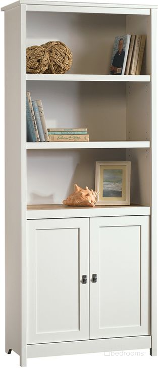 The appearance of Cottage Road Library With Doors In Soft White designed by Sauder in the country / farmhouse interior design. This soft white piece of furniture  was selected by 1StopBedrooms from Cottage Road Collection to add a touch of cosiness and style into your home. Sku: 417593. Product Type: Bookcase. Material: Engineered Wood. Image1