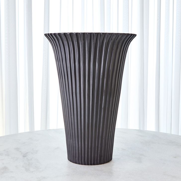 The appearance of Flared Fluted Large Vase In Matte Black designed by Global Views in the modern / contemporary interior design. This black piece of furniture  was selected by 1StopBedrooms from Flared Collection to add a touch of cosiness and style into your home. Sku: 3.31741. Material: Ceramic. Product Type: Vase. Image1