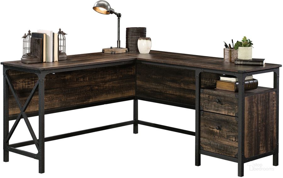 The appearance of Steel River L-Shaped Desk In Carbon Oak designed by Sauder in the country / farmhouse interior design. This carbon oak piece of furniture  was selected by 1StopBedrooms from Steel River Collection to add a touch of cosiness and style into your home. Sku: 423976. Product Type: Desk. Material: Engineered Wood. Image1