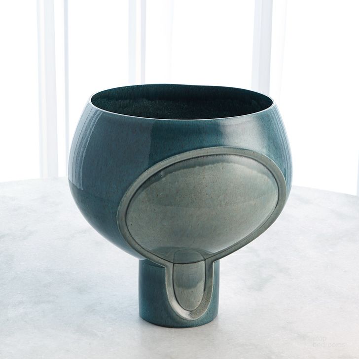 The appearance of Two Tone Pod Squat Vase In Azure designed by Global Views in the modern / contemporary interior design. This blue piece of furniture  was selected by 1StopBedrooms from Two Collection to add a touch of cosiness and style into your home. Sku: 1.10795. Material: Ceramic. Product Type: Vase. Image1