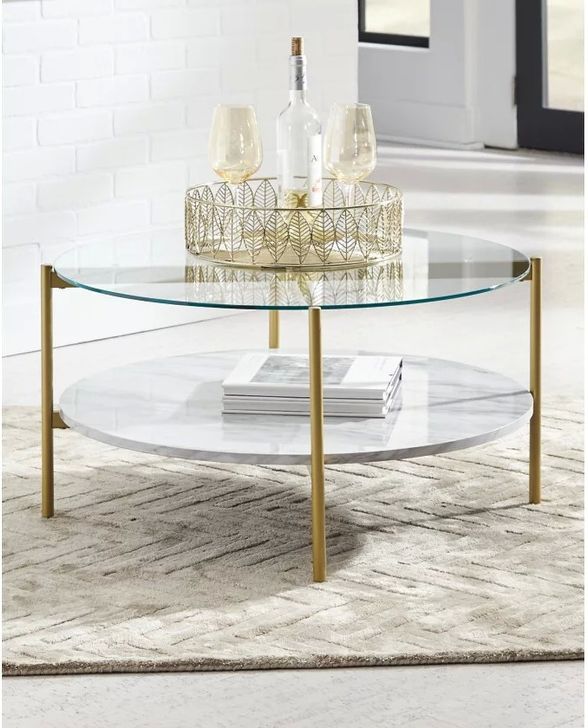 The appearance of Wynora White And Gold Coffee Table designed by Signature Design by Ashley in the transitional interior design. This white/gold piece of furniture  was selected by 1StopBedrooms from Wynora Collection to add a touch of cosiness and style into your home. Sku: T192-8. Material: Glass. Product Type: Coffee and Cocktail Table. Image1