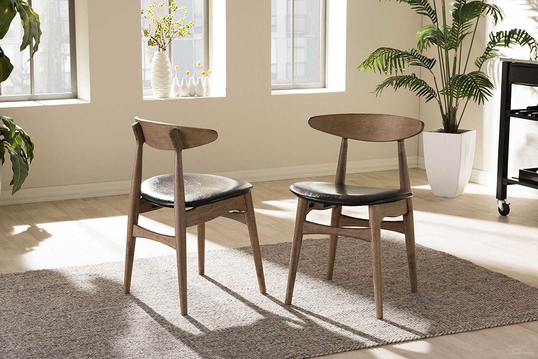 The appearance of Edna Mid-Century Modern French Black Faux Leather And Oak Light Brown Finishing Wood Dining Chair Set of 2 designed by Baxton Studio in the transitional interior design. This black piece of furniture  was selected by 1StopBedrooms from Edna Collection to add a touch of cosiness and style into your home. Sku: Flora-French Oak-DC. Material: Rubberwood. Chair Type: Side Chair.