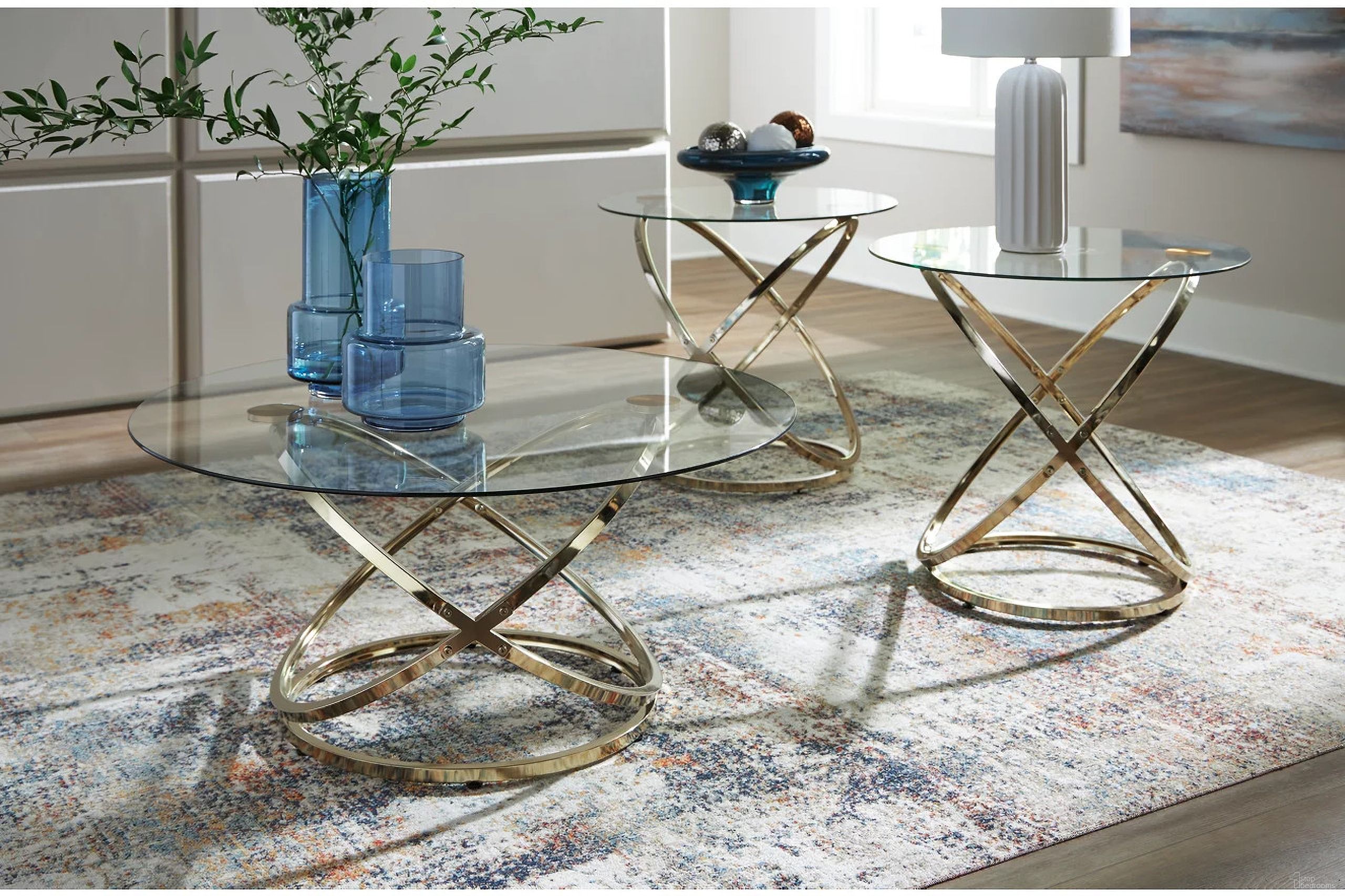 The appearance of Crimonti Table Set of 3 In Champagne designed by Signature Design by Ashley in the modern / contemporary interior design. This champagne piece of furniture  was selected by 1StopBedrooms from Crimonti Collection to add a touch of cosiness and style into your home. Sku: T273-13. Material: Glass.