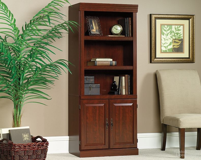 The appearance of Heritage Hill Library With Doors In Classic Cherry designed by Sauder in the traditional interior design. This classic cherry piece of furniture  was selected by 1StopBedrooms from Heritage Hill Collection to add a touch of cosiness and style into your home. Sku: 102792. Material: Engineered Wood.