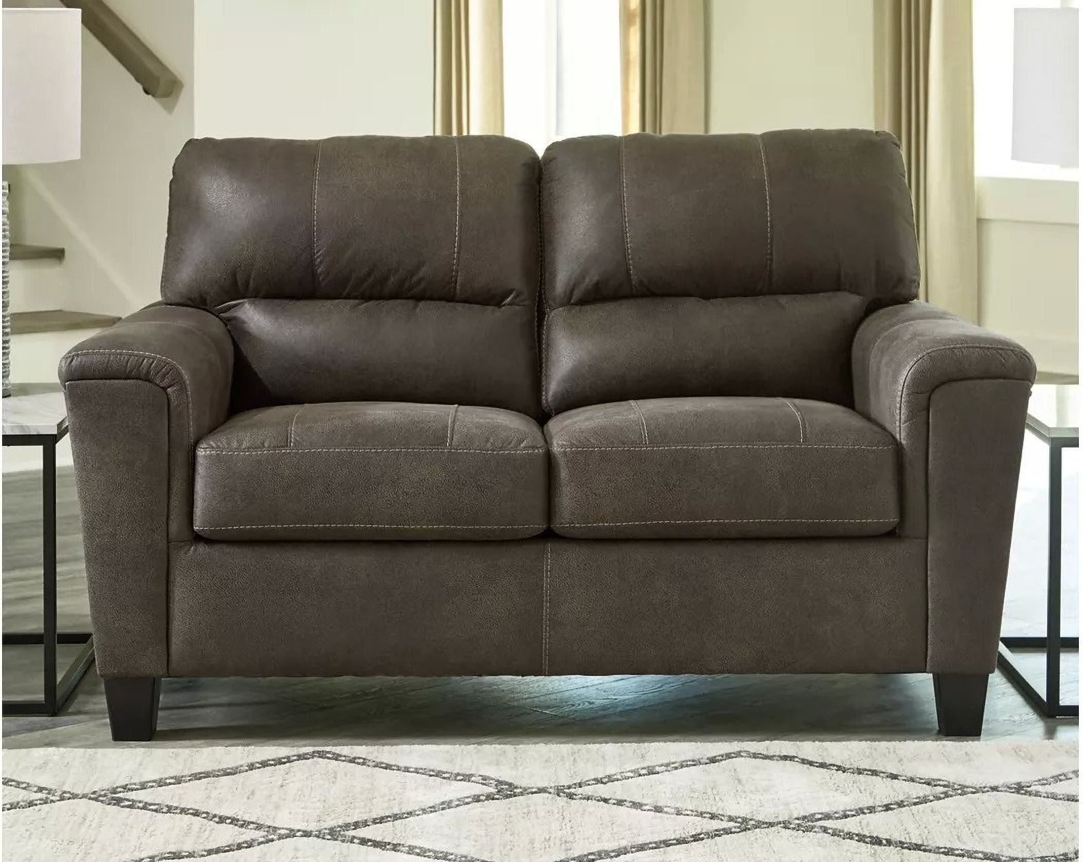The appearance of Navi Loveseat In Smoke designed by Signature Design by Ashley in the modern / contemporary interior design. This smoke piece of furniture  was selected by 1StopBedrooms from Navi Collection to add a touch of cosiness and style into your home. Sku: 9400235. Material: Faux Leather.