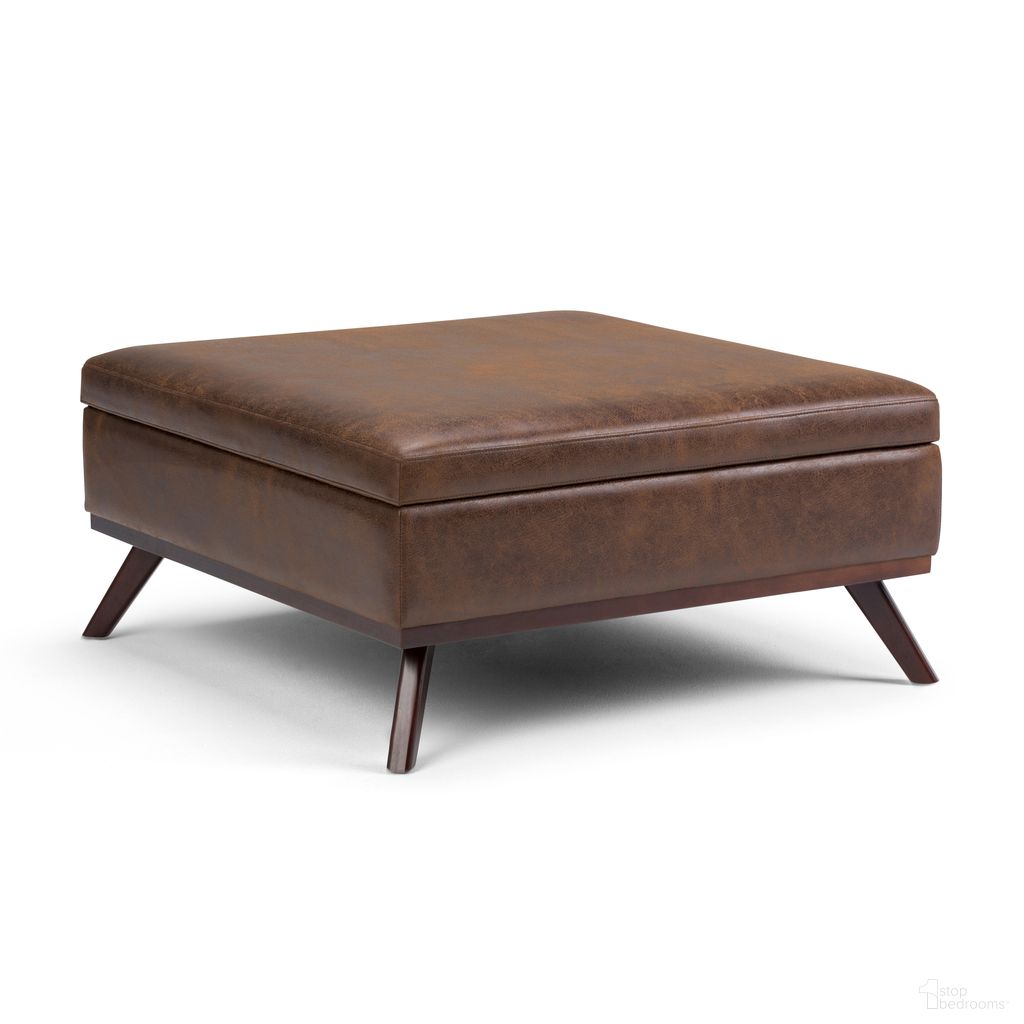 The appearance of Owen Vegan Faux Leather Square Coffee Table Storage Ottoman In Distressed Chestnut Brown designed by Simpli Home in the transitional interior design. This distressed chestnut brown piece of furniture was selected by 1StopBedrooms from Owen Collection to add a touch of cosiness and style into your home. Sku: AXCOT267M-DBR. Material: Faux Leather.