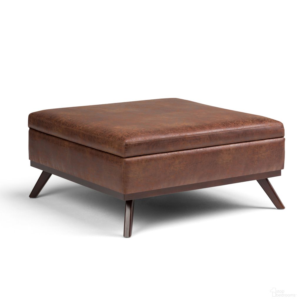 The appearance of Owen Vegan Faux Leather Square Coffee Table Storage Ottoman In Distressed Saddle Brown designed by Simpli Home in the transitional interior design. This distressed saddle brown piece of furniture was selected by 1StopBedrooms from Owen Collection to add a touch of cosiness and style into your home. Sku: AXCOT267M-DSB. Material: Faux Leather.