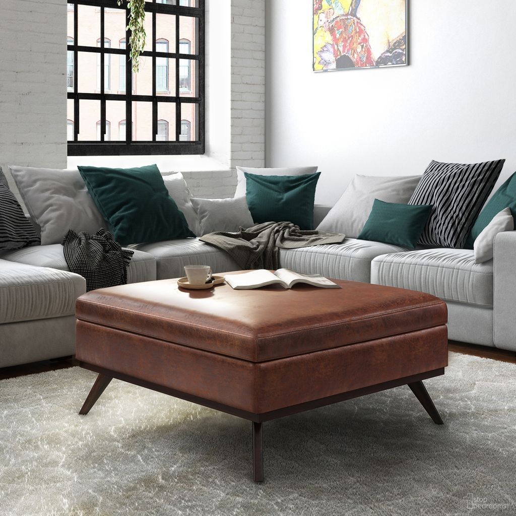 The appearance of Owen Vegan Faux Leather XL Square Coffee Table Storage Ottoman In Distressed Saddle Brown designed by Simpli Home in the transitional interior design. This distressed saddle brown piece of furniture was selected by 1StopBedrooms from Owen Collection to add a touch of cosiness and style into your home. Sku: AXCOT267XL-DSB. Material: Faux Leather.