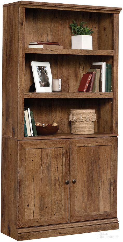 The appearance of Sauder Select Bookcase With Doors In Vintage Oak designed by Sauder in the transitional interior design. This vintage oak piece of furniture  was selected by 1StopBedrooms from Sauder Select Collection to add a touch of cosiness and style into your home. Sku: 426417. Material: Engineered Wood.